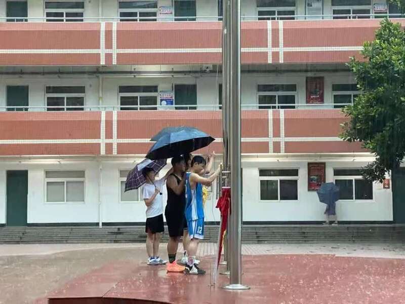 暴雨中少年守护国旗尊严-图1